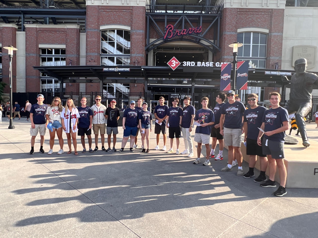 a group of people standing in front of a baseball stadium