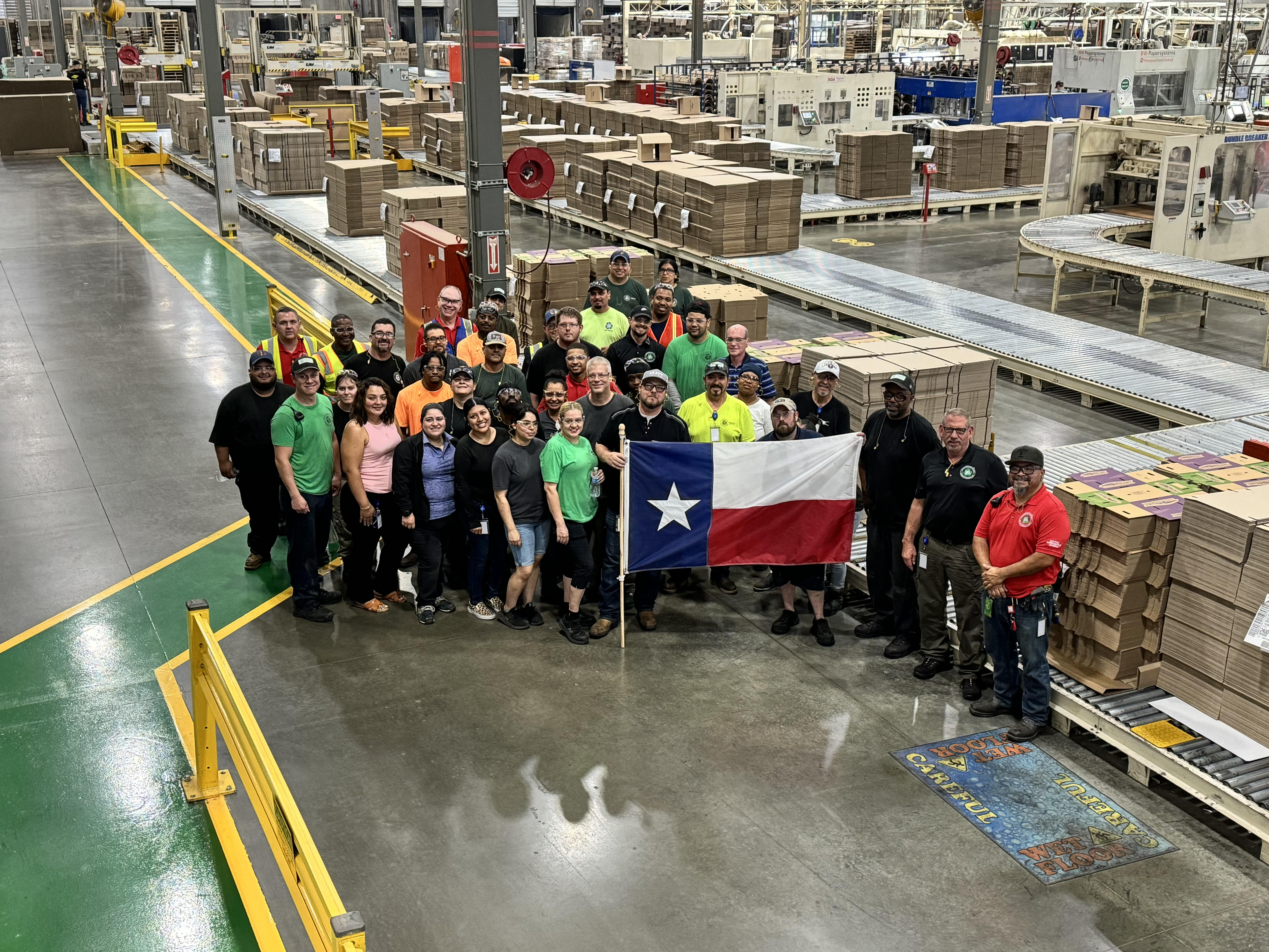 a group of people standing in a factory