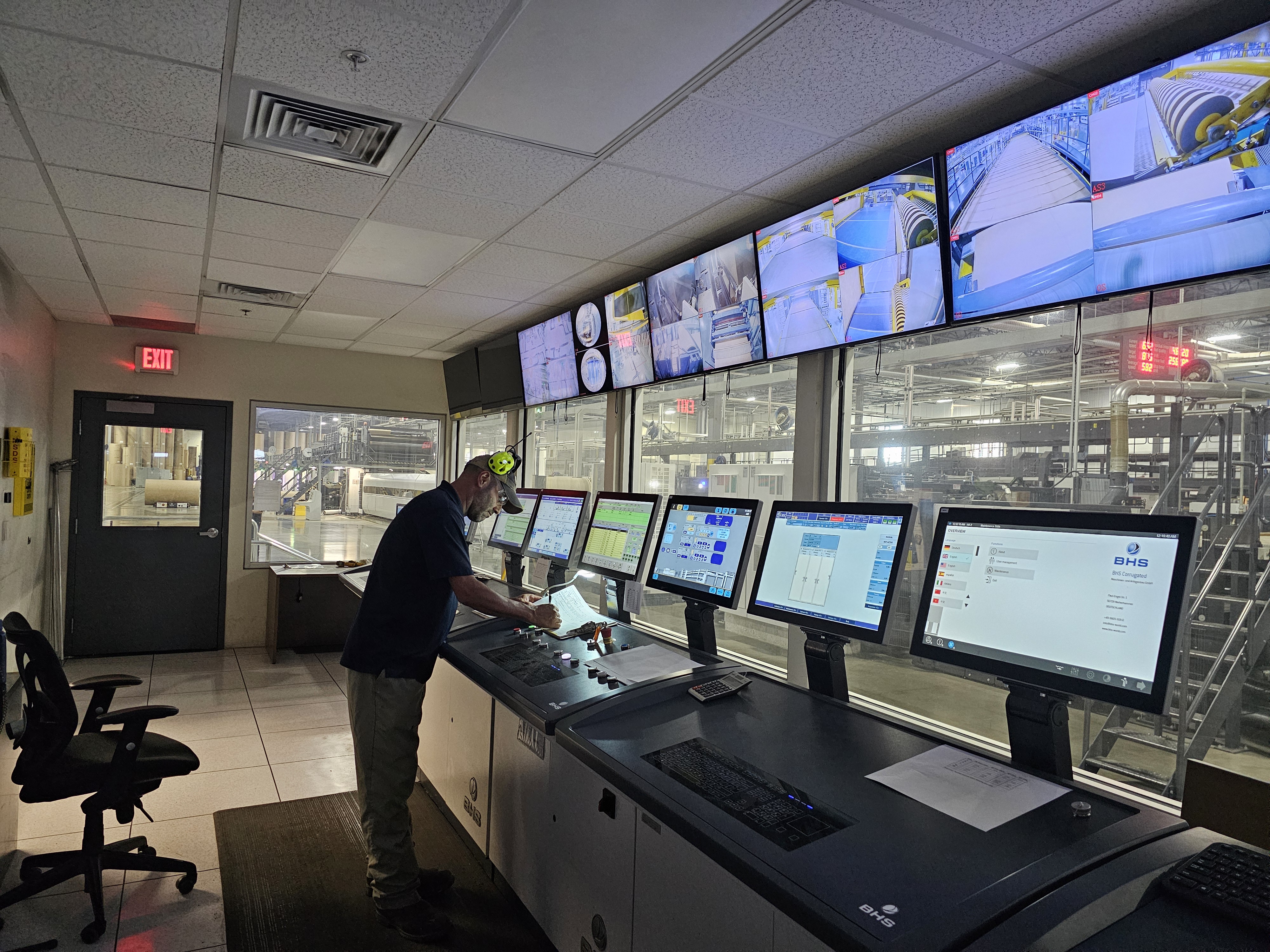 a man standing in front of several monitors