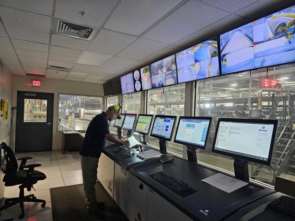 a man standing in front of several monitors