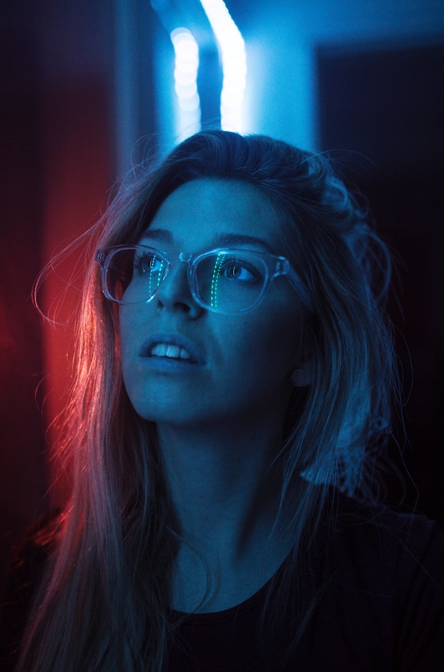 a woman looking up with a blue and red light