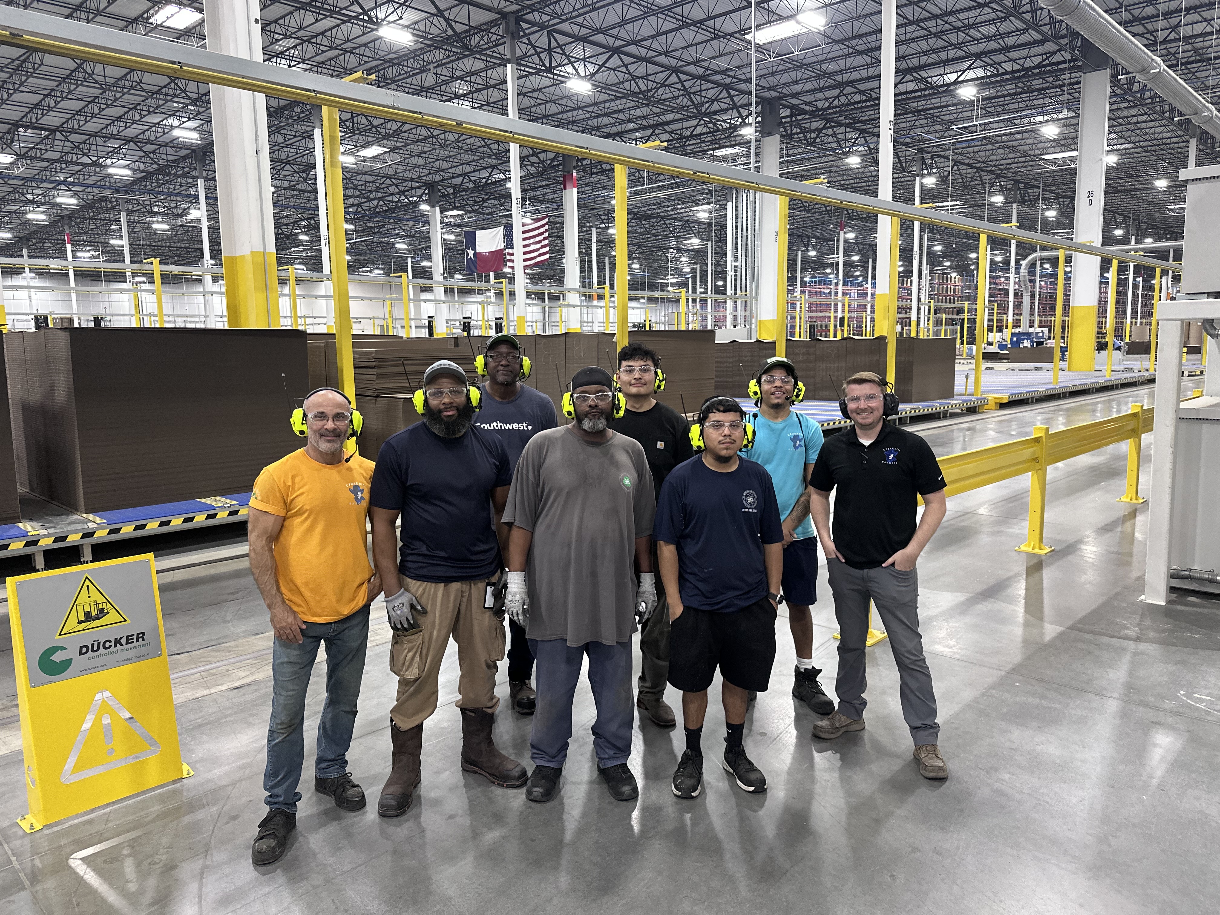 a group of men standing in a warehouse