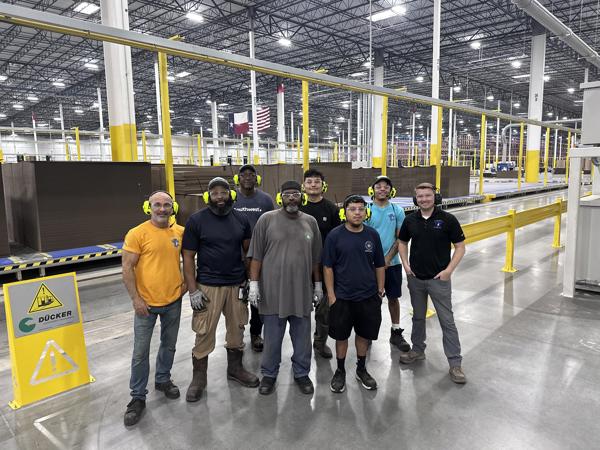 a group of men standing in a warehouse