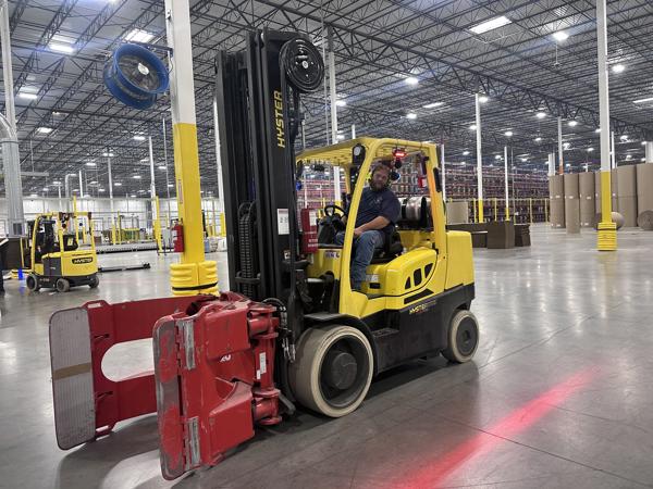 a man driving a forklift in a warehouse