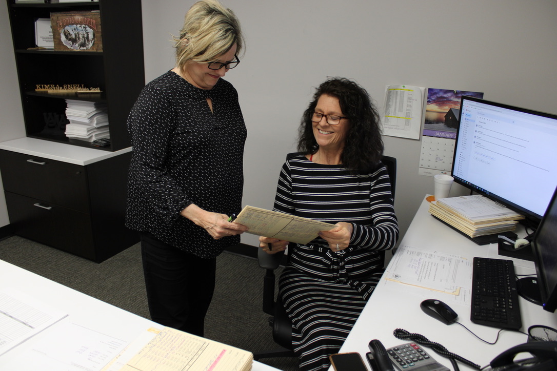 two women looking at a piece of paper
