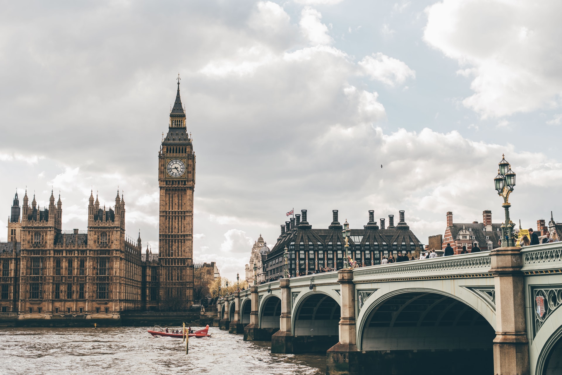 a bridge over water with a clock tower and a boat