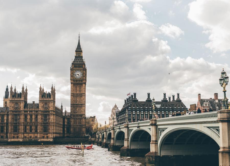a bridge over water with a clock tower and a boat