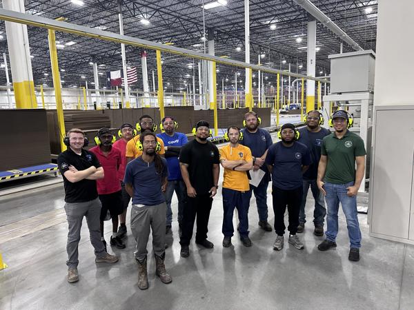 a group of men standing in a factory