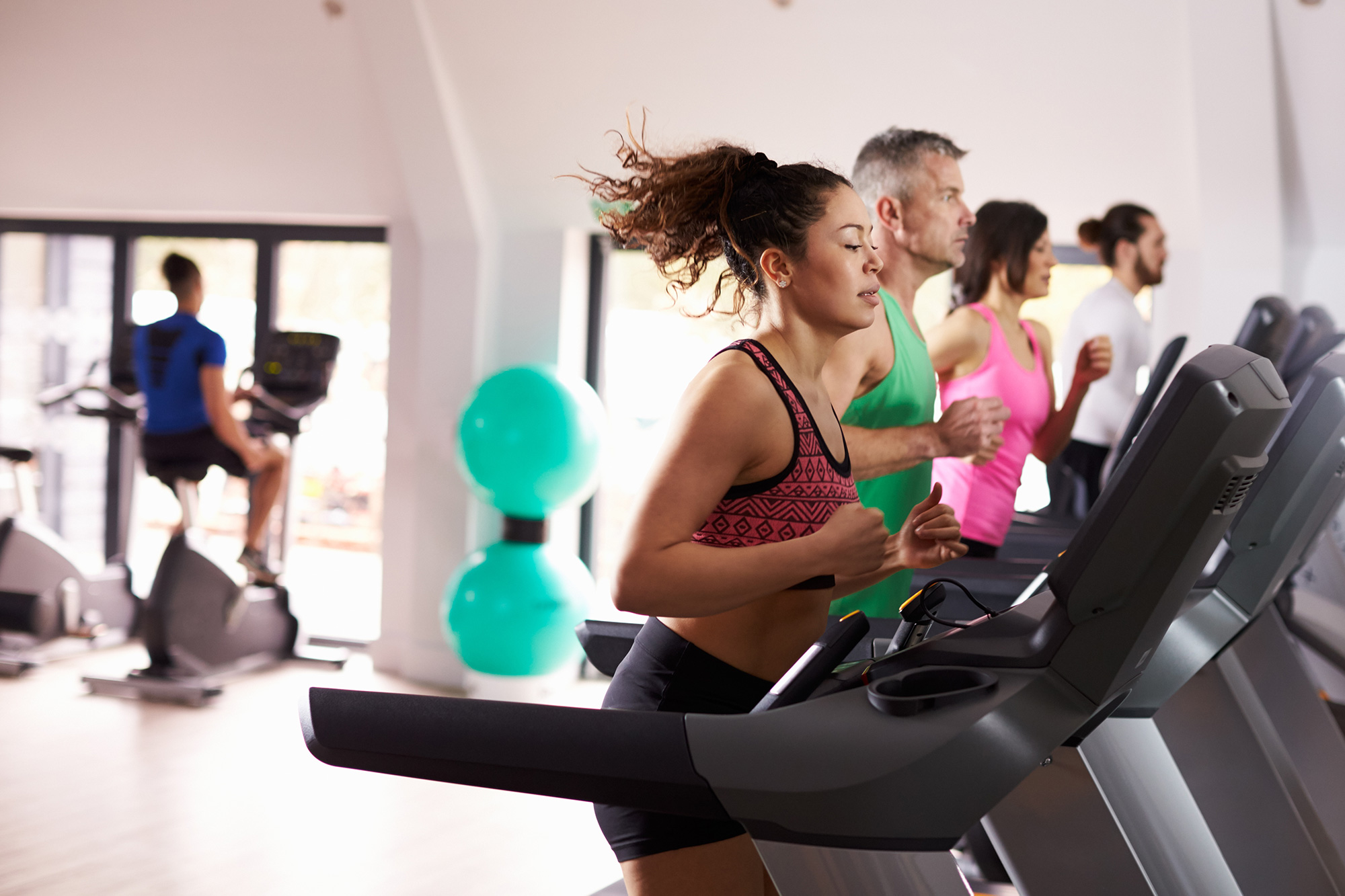 a group of people running on treadmills