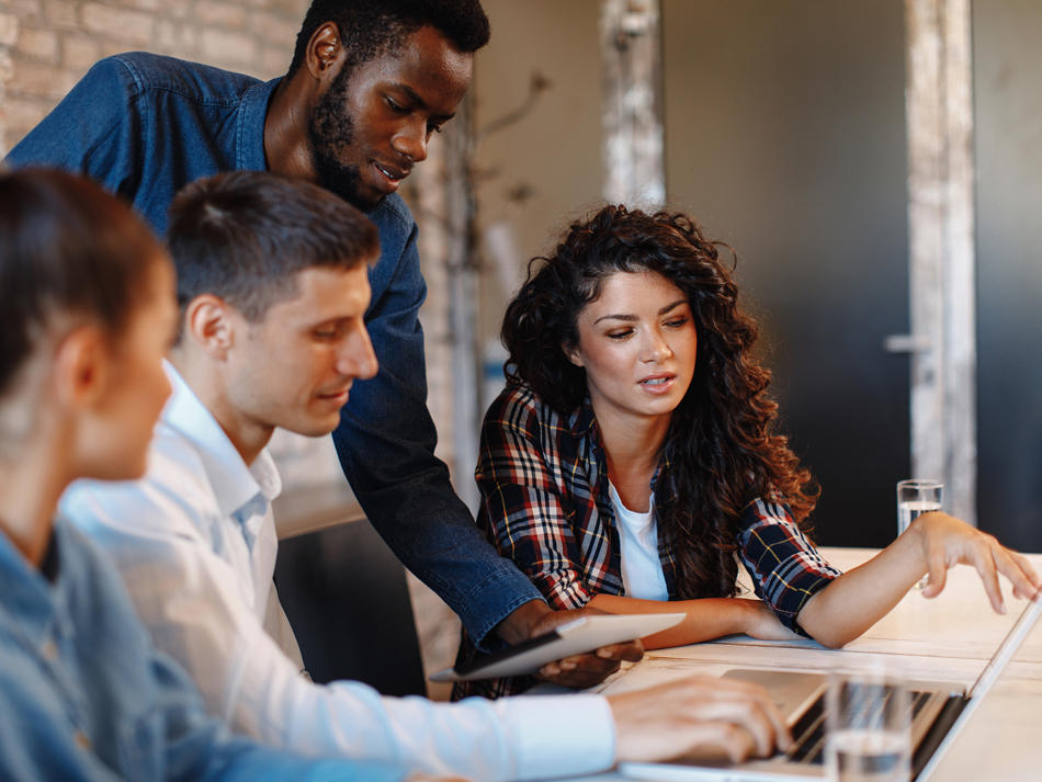 a group of people looking at a laptop