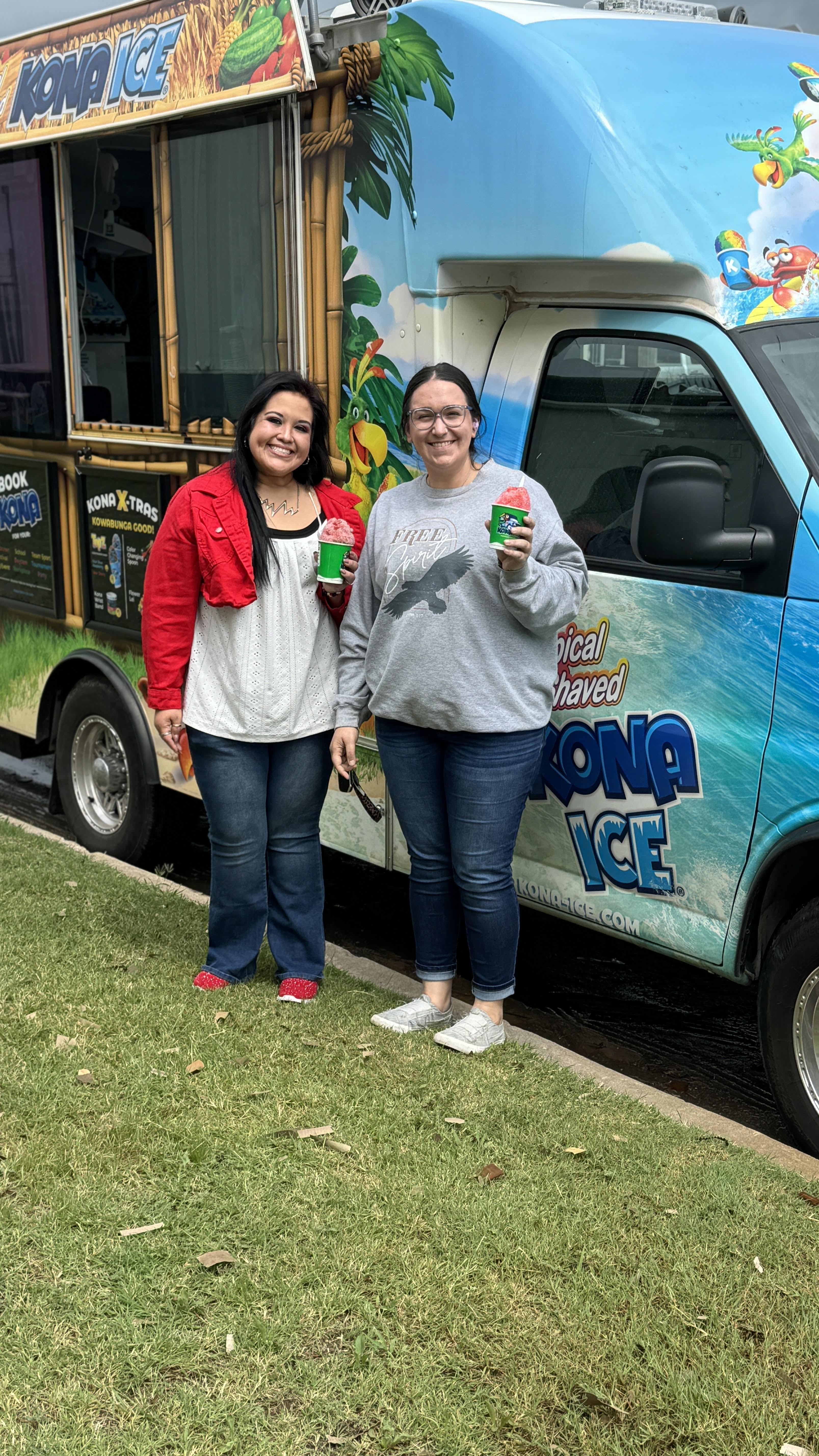 two women standing next to a truck