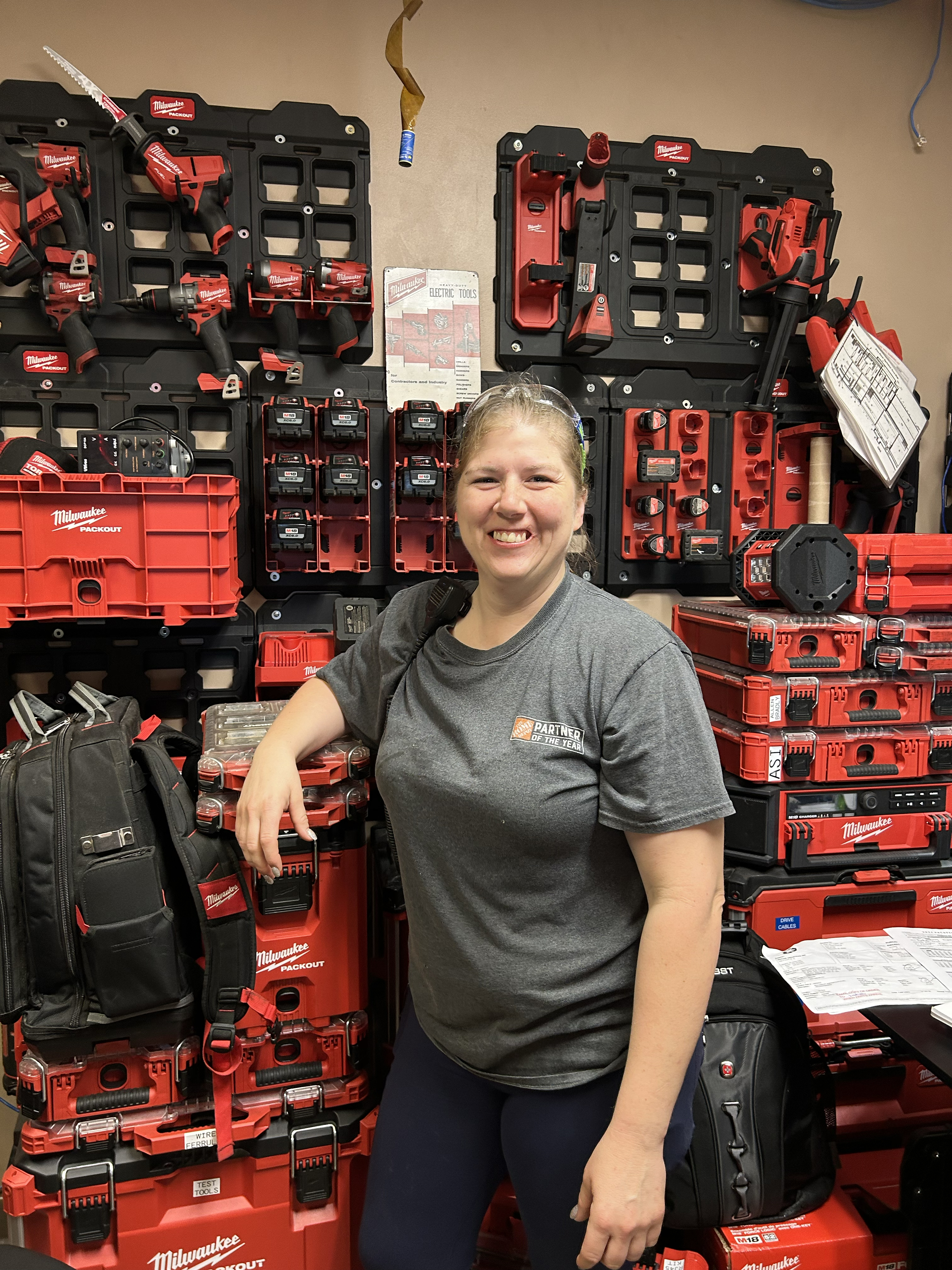 a woman standing in front of a wall of tools