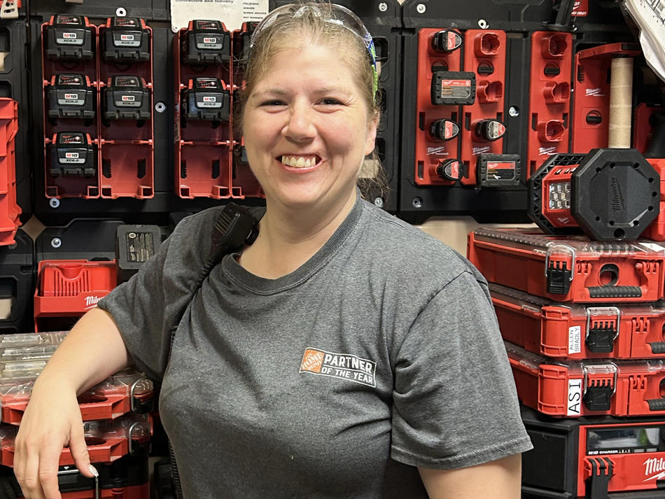 a woman standing in front of a wall of tools