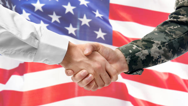 a close-up of a handshake in front of a flag