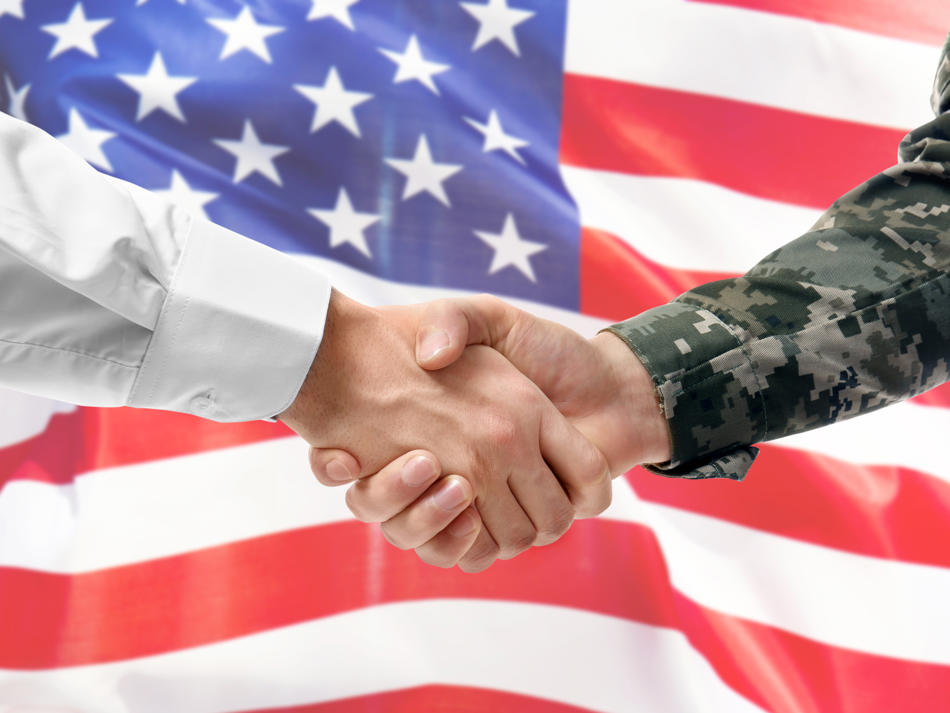 a close-up of a handshake in front of a flag