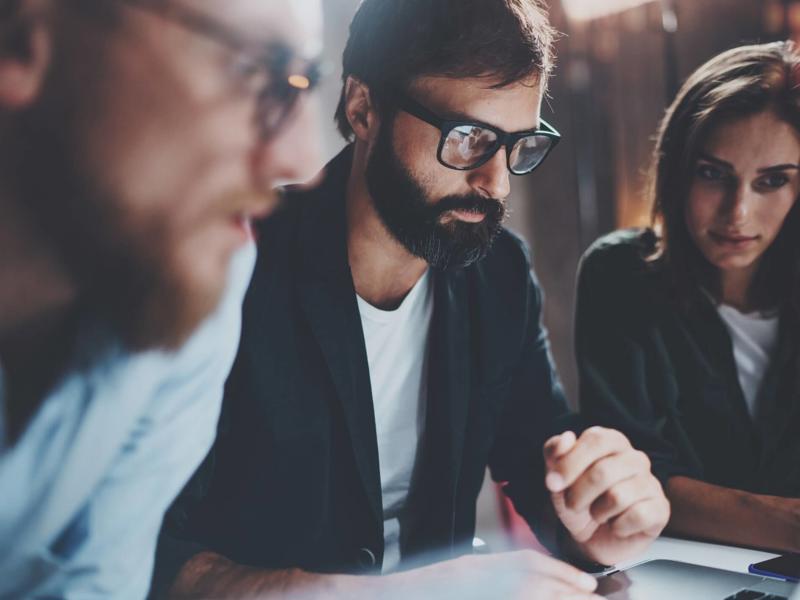 a group of people looking at a laptop
