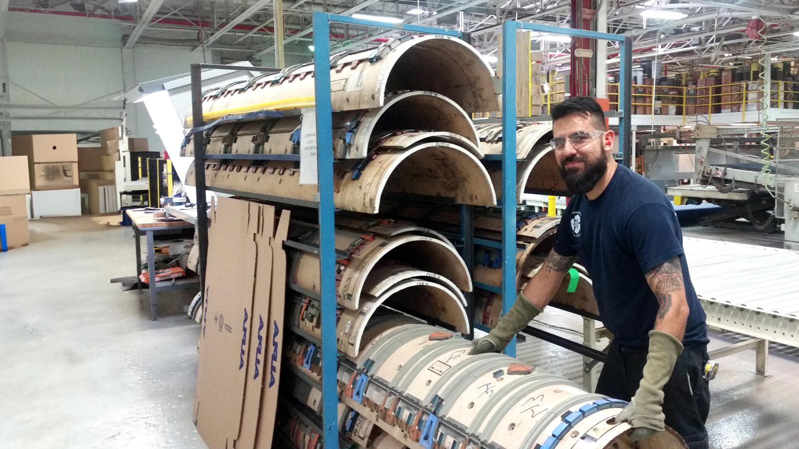 a man standing next to a stack of paper