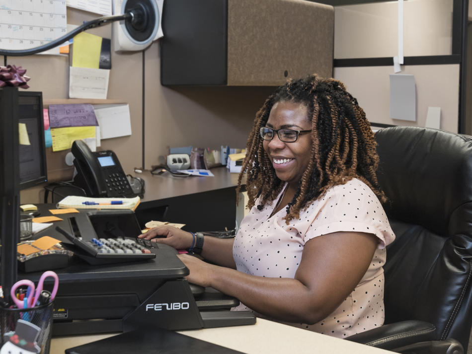 a woman sitting at a desk working on a computer