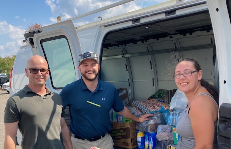 a group of people standing in front of a truck