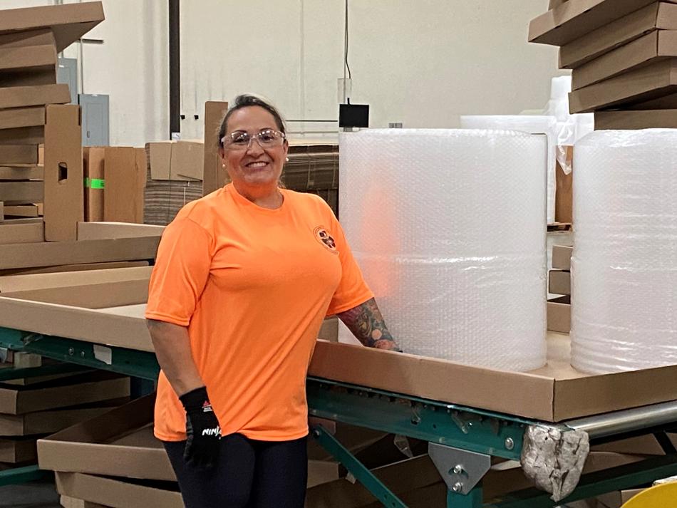 a woman standing next to a large stack of bubble wrap
