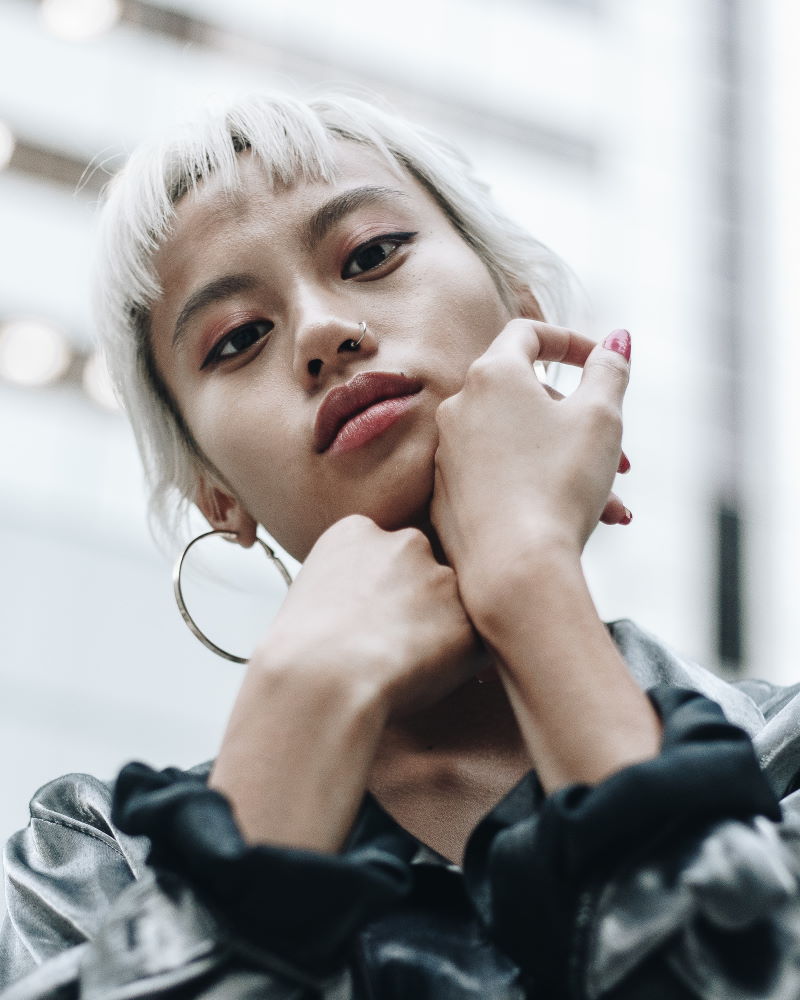 a woman with blonde hair holding her chin