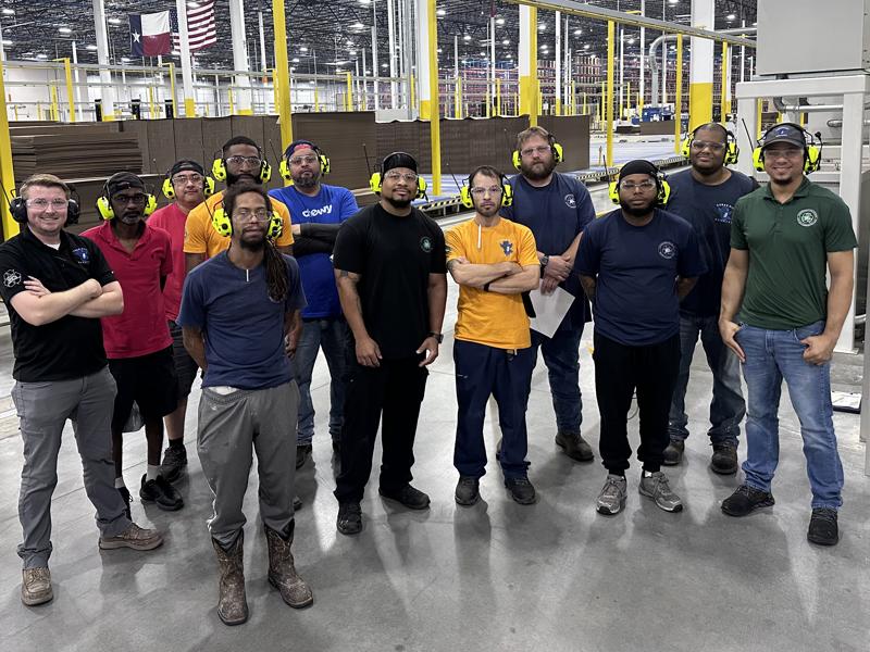 a group of men standing in a factory